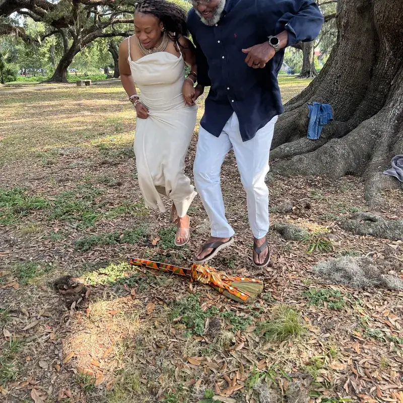 Couple jumping the broom under live oaks in New Orleans